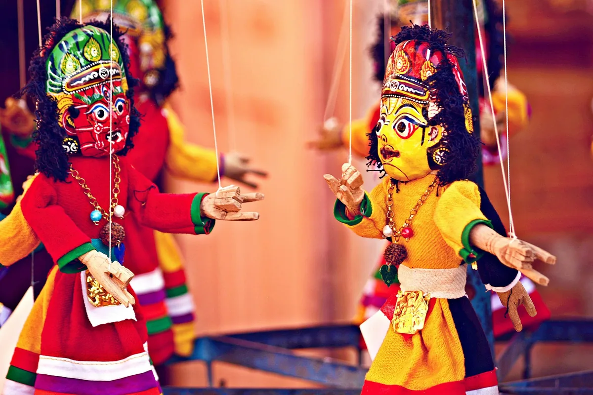 Marionetas de hilo con cabezas talladas y vestuario de colores, suspendidas de sus hilos